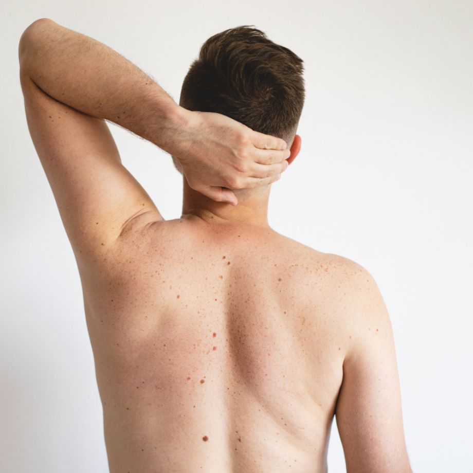a man with his arm holding the back of his head showing his back skin