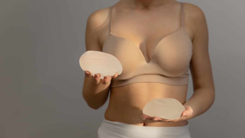 Woman holding types of breast implants