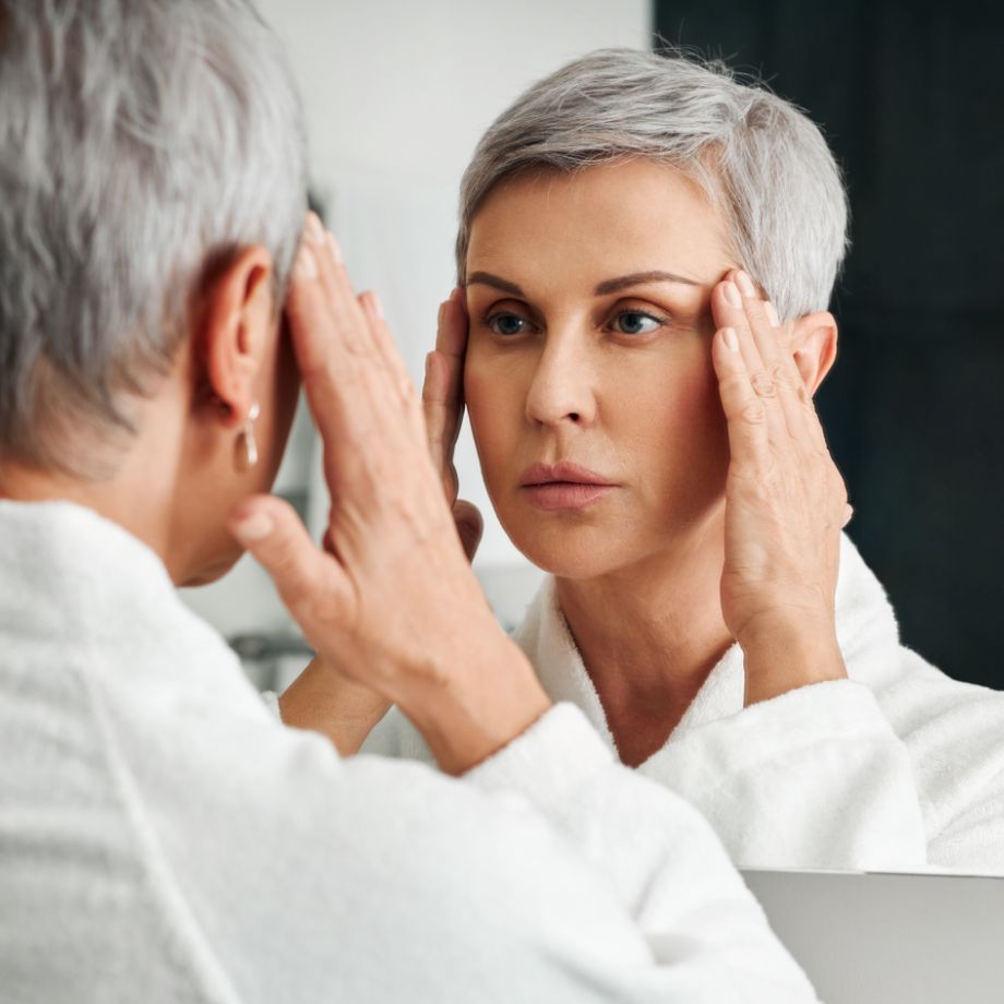 mature woman looking at herself in a mirror